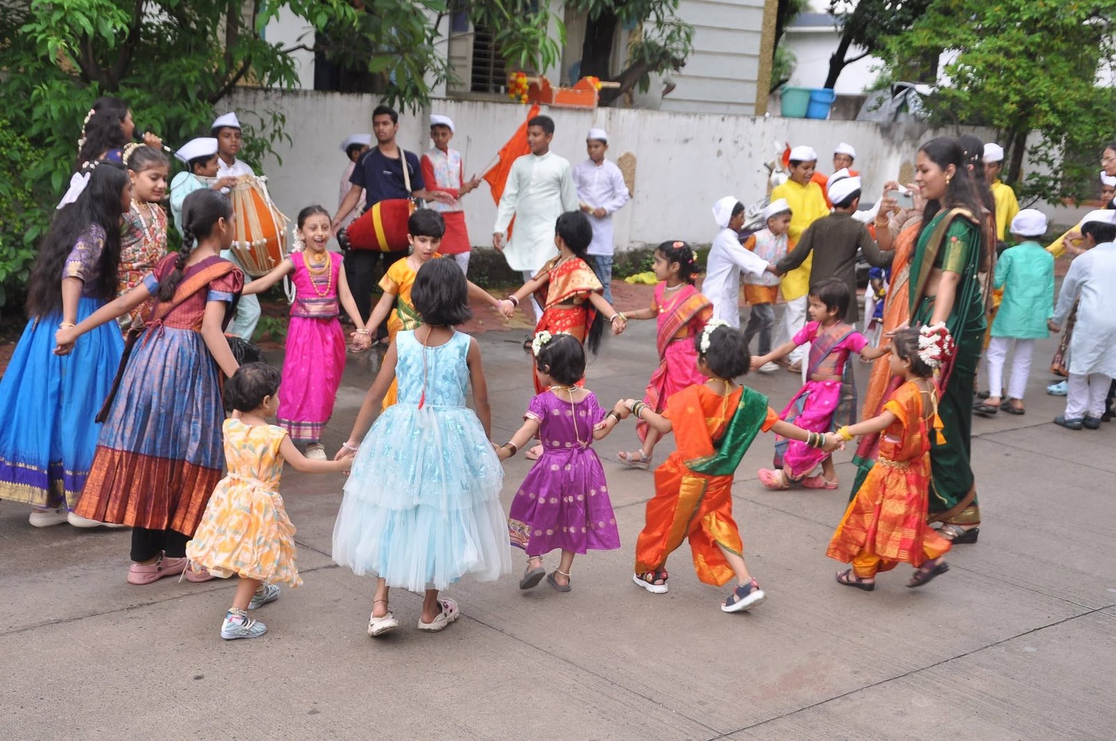 Children in colourful traditional dress dancing together during a Gopal Fun School celebration